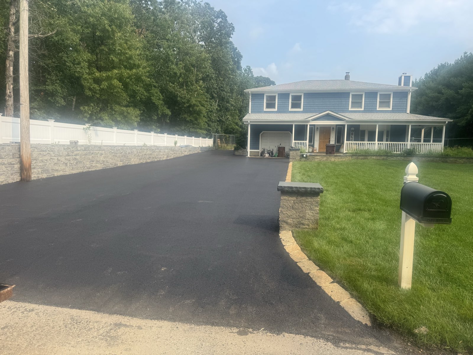 The same residential driveway finished with new asphalt and a block border